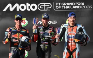 Marco Bezzecchi (Aprilia) festeggia sul gradino più alto del podio la vittoria nel GP di Thailandia 2026 della MotoGP, affiancato da Pedro Acosta (KTM) in seconda posizione.