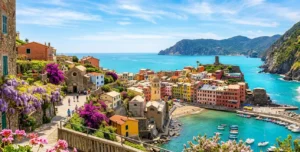 Un incantevole borgo italiano costiero fiorito con bouganville e glicine sotto un cielo primaverile, ideale per le vacanze di Pasqua 2026.